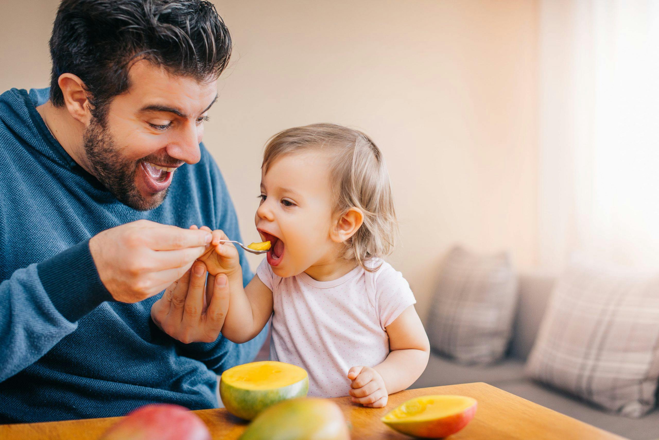 Parent feeding a baby with food high in vitamin D