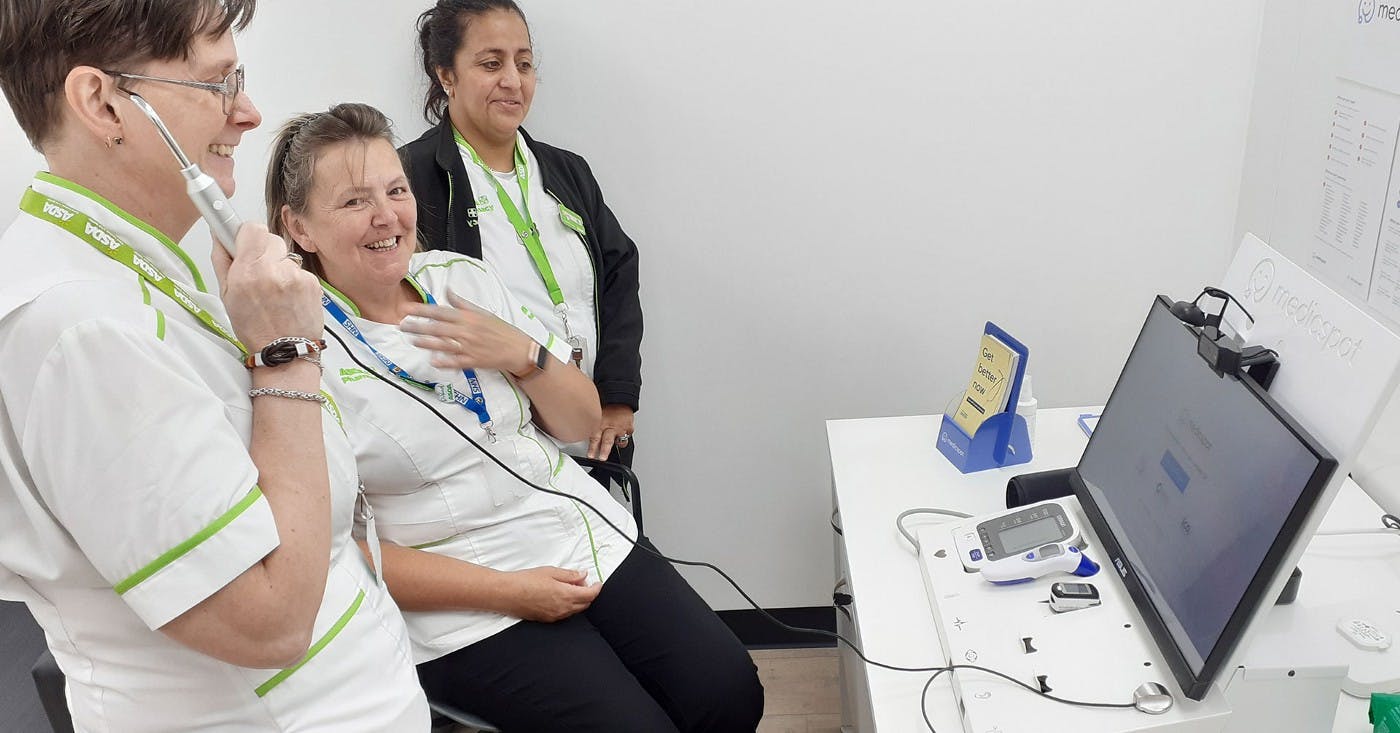 Asda employees with the Medicspot station